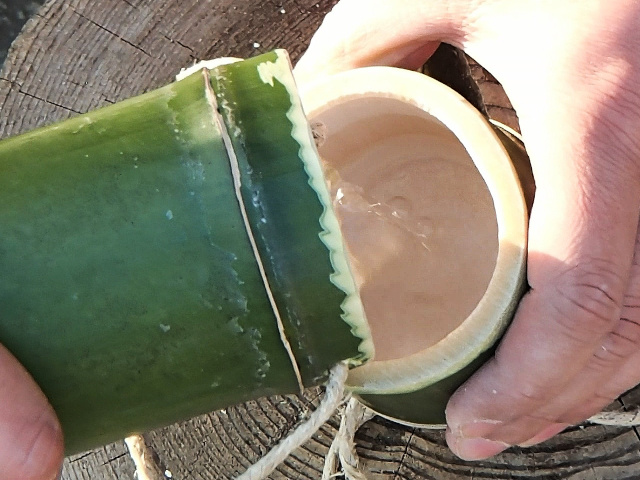 竹コップ付き竹水筒で水を注ぐ